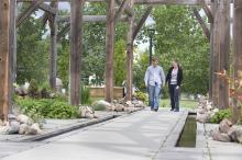 Image of couple walking through Stone Barn Garden in the Leduc Cultural Village