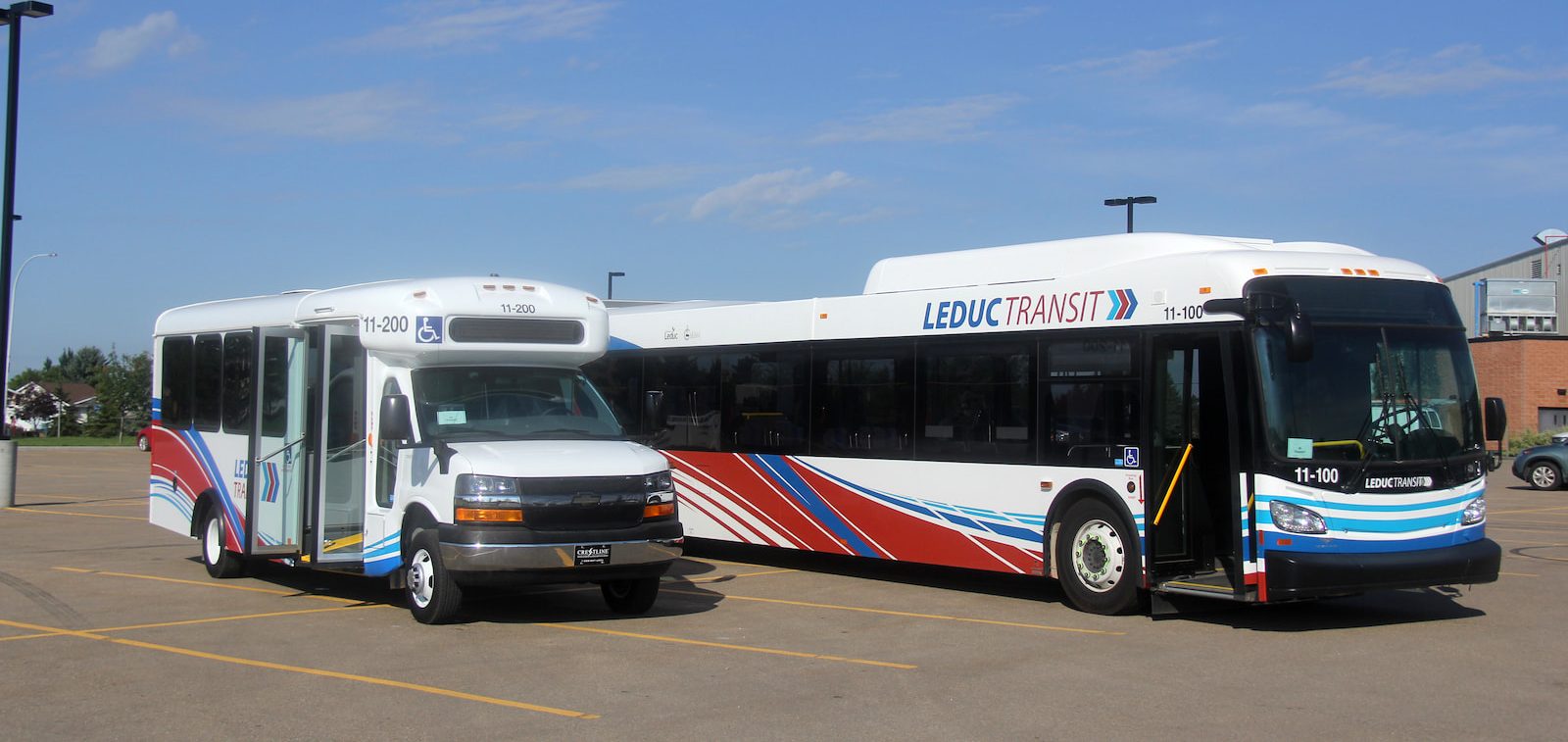 http://Two%20Leduc%20Transit%20buses,%20one%20smaller%20and%20one%20larger,%20parked%20in%20a%20lot%20under%20a%20clear%20blue%20sky.