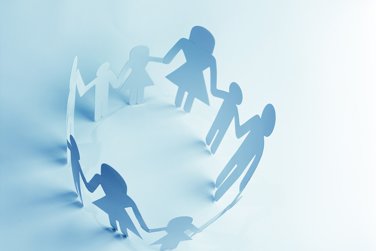 Stock photo of figures resembling parents and children holding hands in a circle.