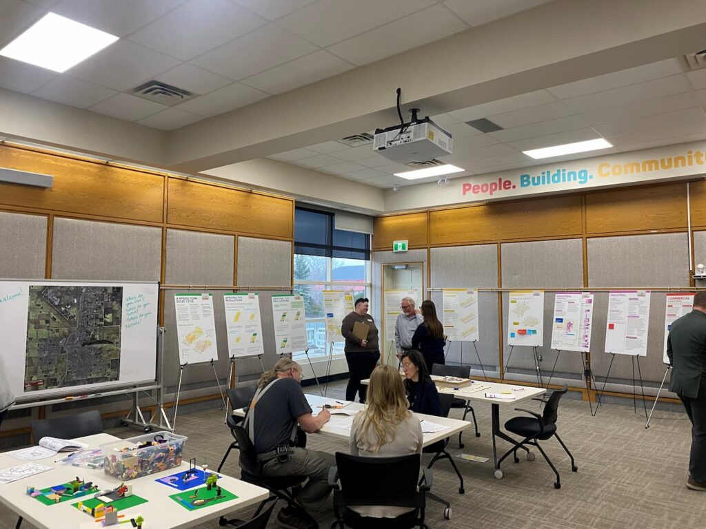 Residents review display boards and discuss planning information at a public engagement session for the draft Leduc Land Use Bylaw.